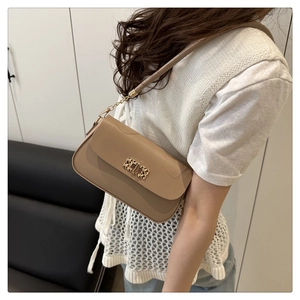 Detail of minimalist beige crossbody bag featuring a golden rectangular metal lock closure