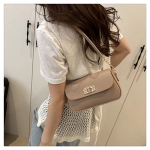 Khaki crossbody bag with gold woven lock and chain strap on a model for size reference