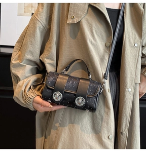 Λεπτομέρεια από ρετρό τσάντα με πουά και διπλά ασημένια κουμπώματα στο μοντέλο