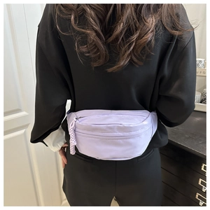 Close-up van een lichtpaarse halvemaanvormige heuptas, casual gedragen als crossbody