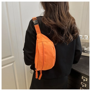 Achteraanzicht van de feloranje crossbody heuptas met koordritsen op zwarte hoodie