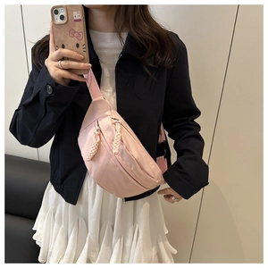 Detail van roze nylon crossbodytas met geweven touw ritsen en een verstelbare schouderriem