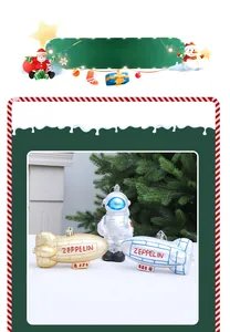Close-up of astronaut and Zeppelin airship ornaments on a green Christmas tree