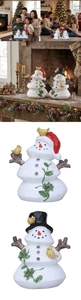 Detailed view of two resin Christmas snowmen with a festive fireplace scene background