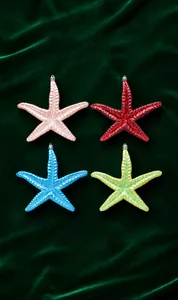 Detailaufnahme bunter Glitzer-Seestern-Anhänger für den Weihnachtsbaum mit silbernen Ösen