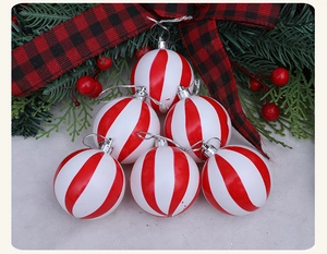 Detalle de bolas de Navidad de rayas rojas y blancas con ramas de pino y bayas rojas