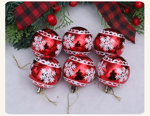 Set of six red Christmas balls with white snowflakes and gold strings on faux snow