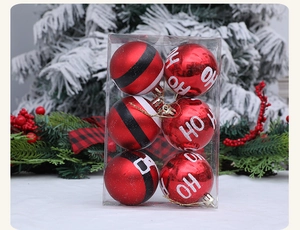 Detail of red Christmas balls with HO HO HO and Santa belt designs in a gift box