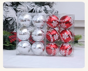 Close-up of red and silver Christmas baubles with white snowflake patterns and festive ribbon