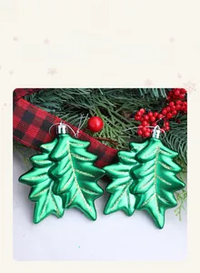 Detail of green leaf Christmas ornaments with gold glitter veins and festive berries