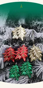 Detail of 8.5cm leaf-shaped Christmas ball ornaments on a frosted pine tree branch