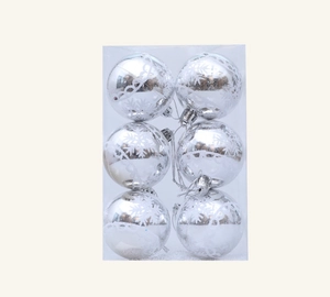 Detail of silver Christmas ornaments with white snowflake patterns in transparent box