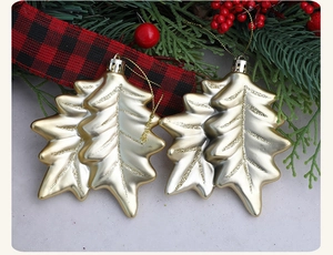 Macro shot of gold glitter leaf Christmas ornaments with silver caps on festive background