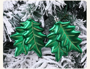 Detail of green holly leaf Christmas ornaments with gold glitter and silver hanging hooks