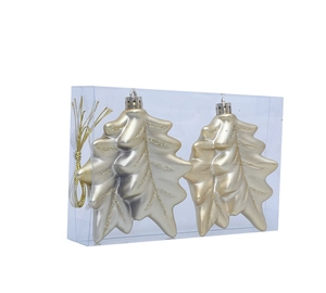 Detail of champagne gold leaf ornaments with glitter edges in a clear gift box