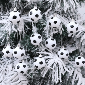 Classic black and white football Christmas ornaments hanging on a snowy Christmas tree