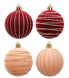 Detailed view of red and pink flocked Christmas balls with golden glitter stripe patterns