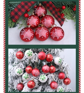 Primer plano de bolas navideñas rojas y blancas con estrellas y copos de nieve en un árbol nevado