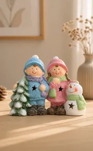 Close-up of ceramic Christmas boy and girl figurines with snow texture and festive details