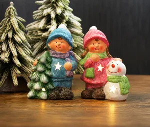 Detail of glowing Christmas figurines with star cutouts on a rustic wooden surface