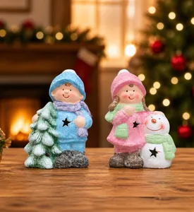 Detail of Christmas figurines showing boy with tree and girl with snowman decorations