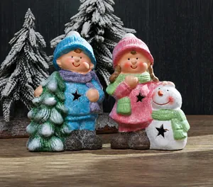 Close-up of ceramic Christmas figurines with star cutouts and festive knit outfits