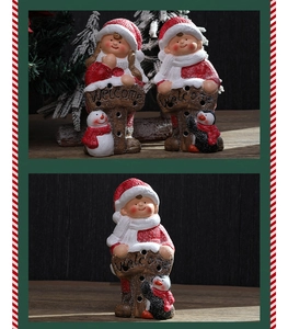 Close-up of ceramic Christmas figurines holding Welcome signs with penguin and snowman