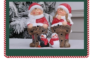 Detailed view of resin Christmas figures holding a Welcome sign with snowman and penguin