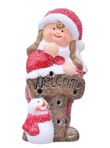 Close-up of a Christmas ceramic girl and snowman with a Welcome sign and snowy texture