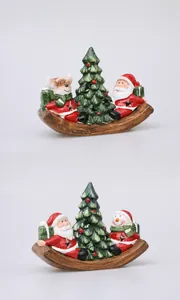 Detail of resin Christmas canoe ornaments with Santa, snowman and festive pine trees