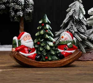 Detail of Santa and Snowman ceramic Christmas ornament on a rocking wooden base