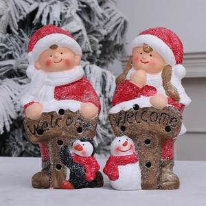 Cute boy and girl Christmas tabletop figurines with Welcome signs and artificial snow