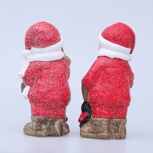 Vista posteriore di statuette natalizie in ceramica luminose con dettagli effetto neve