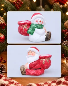 Close-up of Santa Claus and snowman candle holders with festive snowy finish and gift bags