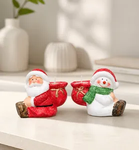 Detail of Santa Claus and Snowman figurines holding candles for Christmas table decor