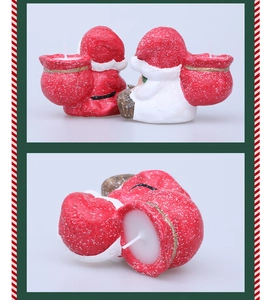 Detail of Santa Claus shaped ceramic paraffin candles with glitter snow and gift bag
