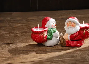 Close-up of ceramic Santa and snowman paraffin candles with festive snowy texture finish