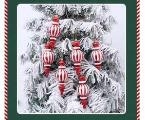 Primer plano de adornos navideños de rayas rojas y blancas en un árbol nevado