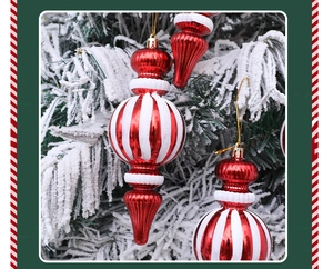 Detalle de adornos navideños con rayas rojas y blancas colgados en una rama nevada
