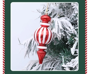 Detalle de adornos navideños de rayas rojas y blancas con purpurina en ramas de pino nevadas