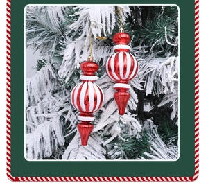 Detalle de bolas de Navidad de rayas rojas y blancas en una rama de pino nevada