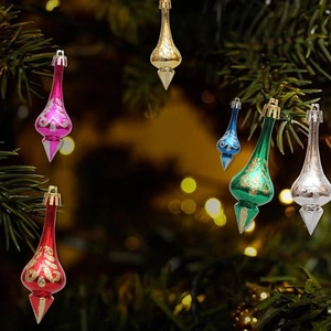Glittery Christmas drop ornaments in multiple colors hanging on a festive Xmas tree