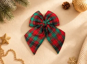 Detail of red and green tartan Christmas bow with gold trim and textured fabric finish