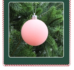 Detail of pink flocked Christmas ball with matte velvet texture hanging on a green tree
