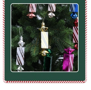 Dettaglio di ornamenti natalizi a forma di caramella colorata e glitterata su un albero verde