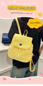 Close-up of lightweight yellow drawstring backpack with textured fabric and flap cover