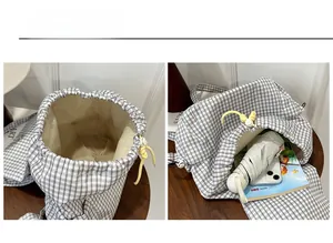 Detail view of plaid drawstring backpack interior with umbrella and phone storage