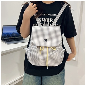 Detail of grey plaid drawstring backpack featuring yellow cords and a stylish bow