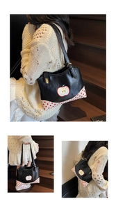 Detail view of black tote bag featuring apple print and red polka dot corner patterns