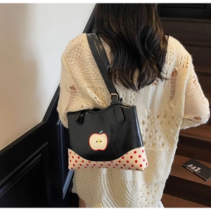Rear view of a model wearing the apple print tote bag with red polka dot details
